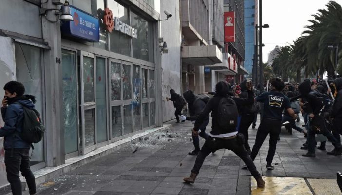 Encapuchados vandalizan edificios en marcha por Ayotzinapa