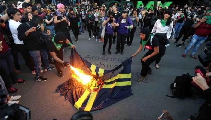 Feministas queman bandera del América en protesta