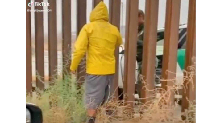 Joven mexicano vende tamales a agente fronterizo a través del muro